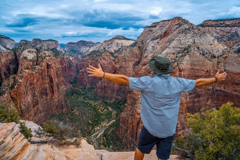 A man celebrating the trekking of Angels Landing Trail in Zion National Park