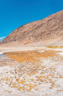 Vertical panoramic of the water in the immense white salt flat of Badwater Basin