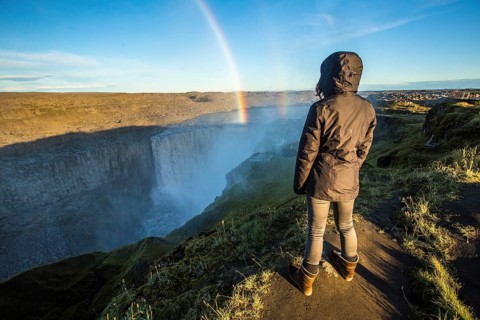 A young woman looking at the Dettifoss Waterfall