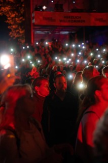 Crowd with mobile phone lights at Live Klostersommer Festival in Historic Monastery
