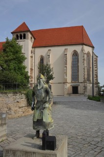 Late Gothic collegiate church with sculpture of medieval knight