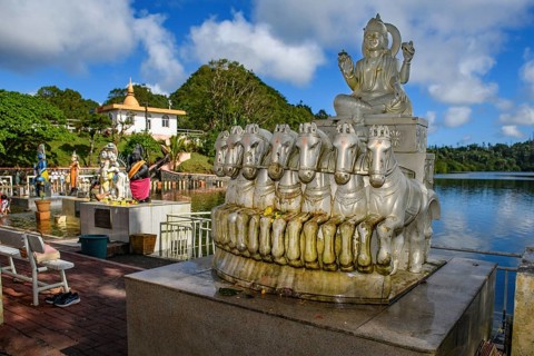 God deity Surya with seven horses personification of sun heat light at religious site largest Hindu sanctuary sanctuary for religion Hinduism outside of India for devout Hindu Hindus in background Sac...