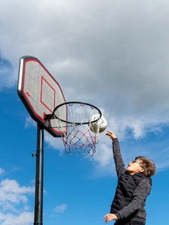 Basketball jumping with the ball to the basket and net