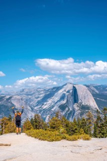 A young man celebrating that he has come walking to Sentinel Dome in Yosemite National Park. United States