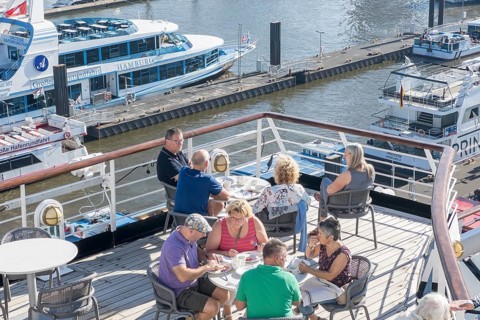 Passengers sitting at tables on the Lido Deck of the cruise ship Vasco da Gama moored at the Ueberseebruecke in the Port of Hamburg