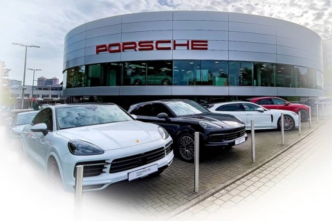 View of futuristic looking building with typical reduced architecture of showroom sales house of car brand car manufacturer Porsche with lettering Porsche at representation of car dealer Gottfried Sch...