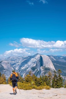A young man walking along Sentinel Dome looking at Yosemite National Park. United States