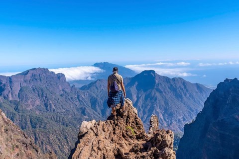 A young man after finishing the trek at the top of the volcano of Caldera de Taburiente near Roque de los Muchachos one summer afternoon