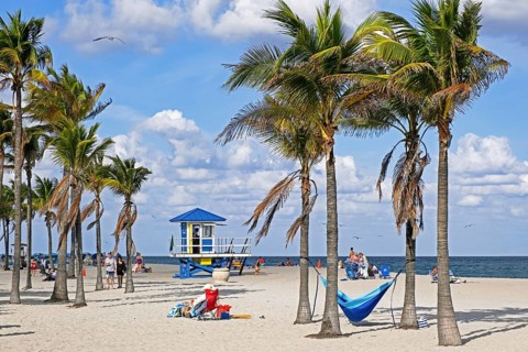 Tourists and lifeguard tower in winter on Surfside Beach along the Atlantic Ocean in Miami-Dade County