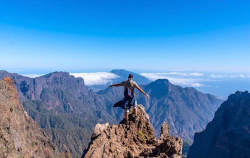 A young man after finishing the trek at the top of the volcano of Caldera de Taburiente near Roque de los Muchachos one summer afternoon