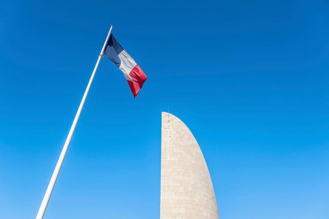 French national flag in front of the memorial Lighthouse of Remembrance at the former concentration camp Natzweiler-Struthof