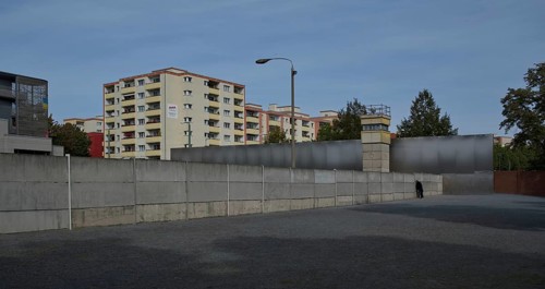 Visitors to the Wall memorial look through slits between the concrete elements at the former death strip