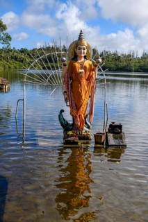 Hindu goddess statue figure sculpture of goddess deity Parvati woman consort Shakti of Lord Shiva Hindu mother goddess mother of Ganesha stands in lake sacred Hindu lake Ganga Talao at religious site ...
