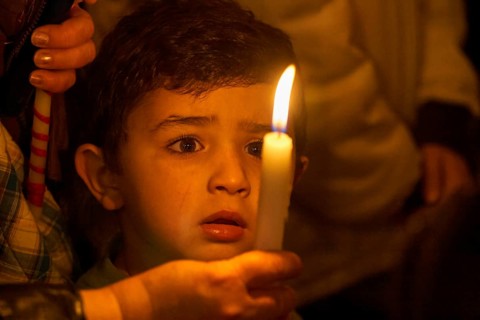 Little boy looking spellbound at a candle
