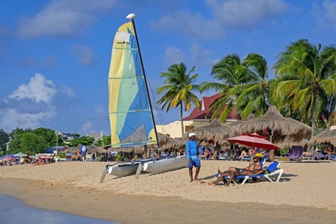 Tourists sunning on sandy beach of Rodney Bay