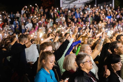 Crowd with mobile phone lights at Live Klostersommer Festival in Historic Monastery