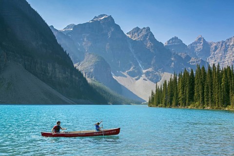 Tourists in canoe on Moraine Lake in the Valley of the Ten Peaks