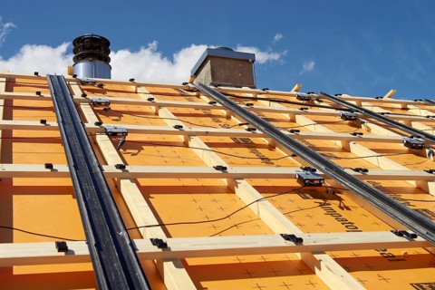 Substructure for an in-roof photovoltaic system on a roof. With foil for increased demands. Rails for rain drainage. Hooks for the solar modules