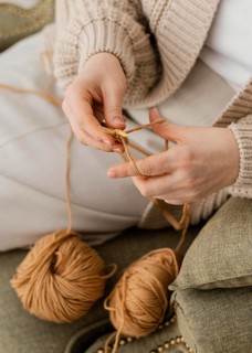 Close up hands knitting with yarn