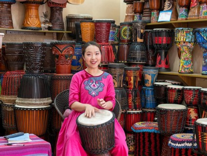 Young Chinese woman drumming and singing
