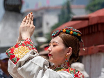 Tibetan young woman with festive hair decoration and splendid clothing