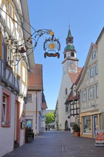 View through alley to Nikolauskirche and nose sign of Gasthof Zur Sonne