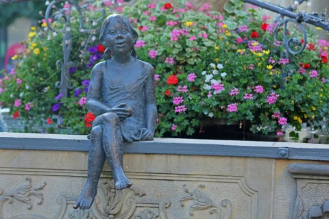 Sculpture Girl with flower decoration at the market fountain