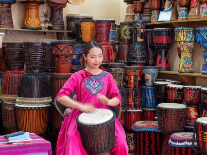 Young Chinese woman drumming and singing