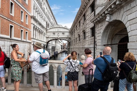 Tourists on the Ponte de Paglia visit the Bridge of Sighs