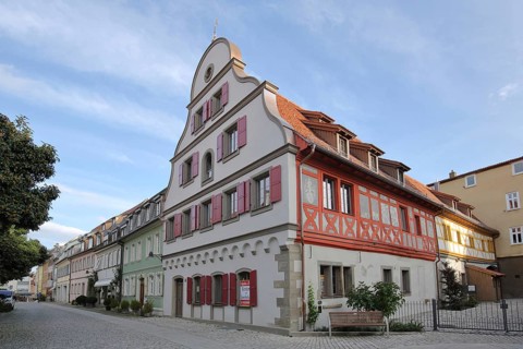 Half-timbered house with tail gable and red shutters