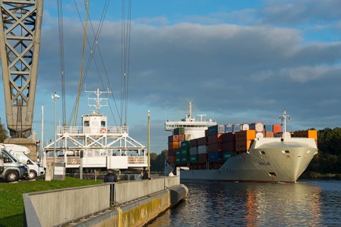Suspended ferry and ship under the Rendsburg railway high bridge over the Kiel Canal