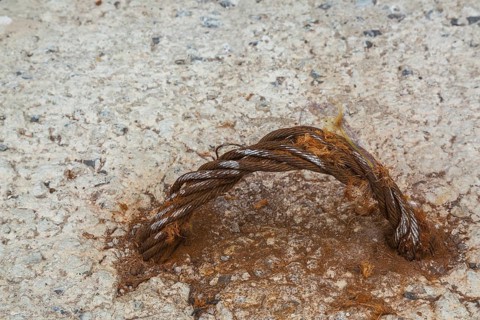 Handle shaped rusted steel cable encased in concrete block
