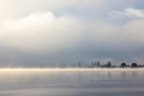 Fog over Lake Constance on an autumn morning with boats