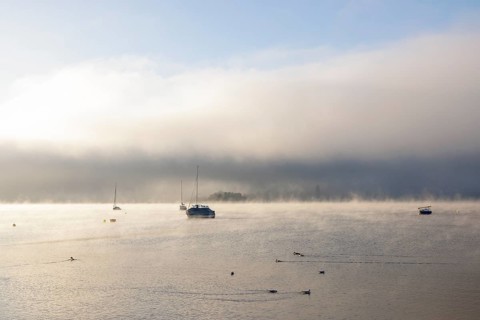 Fog over Lake Constance on an autumn morning with boats