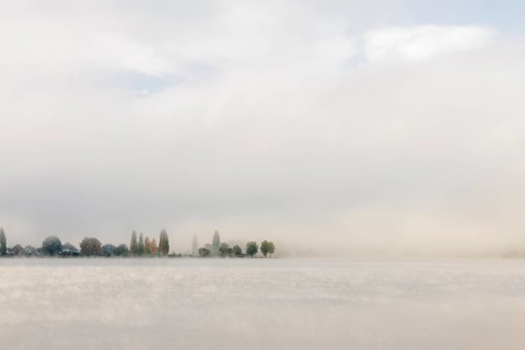 Fog over Lake Constance on an autumn morning with boats