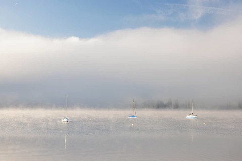 Fog over Lake Constance on an autumn morning with boats