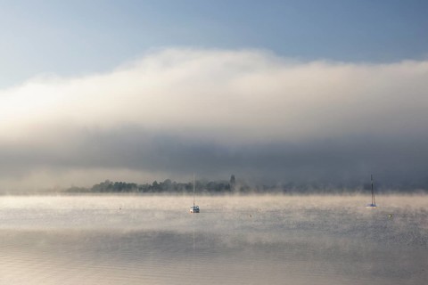 Fog over Lake Constance on an autumn morning with boats