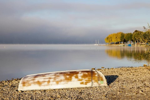 Fog over Lake Constance on an autumn morning with boats