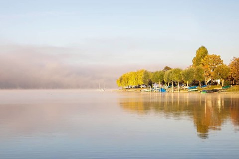 Fog over Lake Constance on an autumn morning with boats