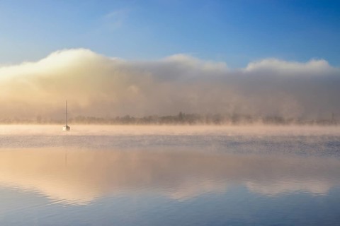 Fog over Lake Constance on an autumn morning with boats