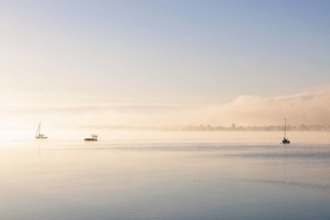 Fog over Lake Constance on an autumn morning with boats
