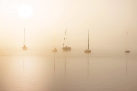Fog over Lake Constance on an autumn morning with boats