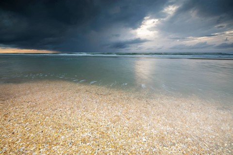 Evening mood with cloudy sky and rain on the beach and in the dunes of De Panne