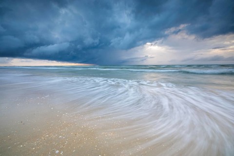 Evening mood with cloudy sky and rain on the beach and in the dunes of De Panne