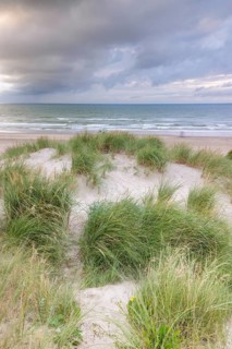Evening mood with cloudy sky and rain on the beach and in the dunes of De Panne