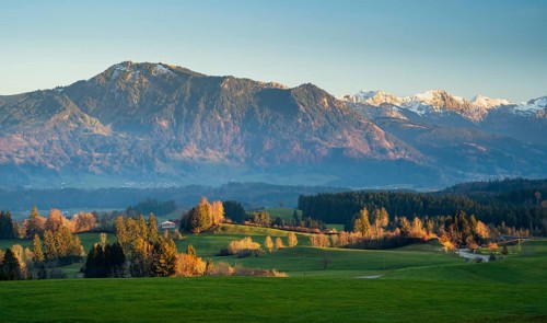 Autumn landscape in the Allgäu. View of the Grünten mountain at golden hour. Meadows and trees in autumn leaves in the foreground. Immenstadt im Allgäu area