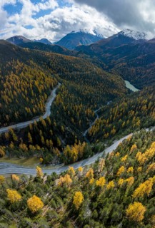 Colourful autumn landscape with a view of the Swiss National Park and the Lai dad Ova Spin reservoir