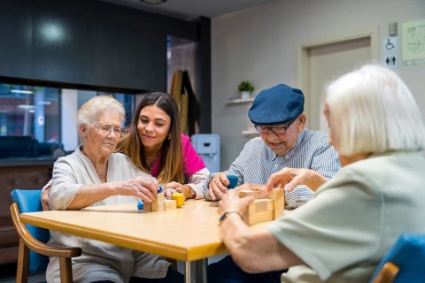 Elderly people and a nurse in a nursing home sharing skills games