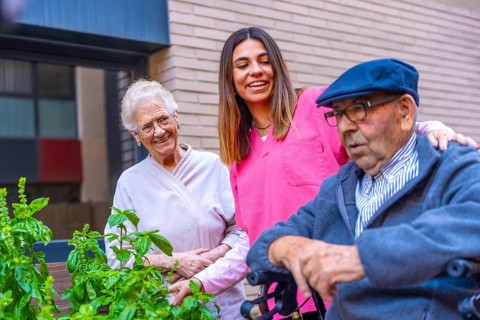 Nurse and seniors in a vegetable garden in a nursing home