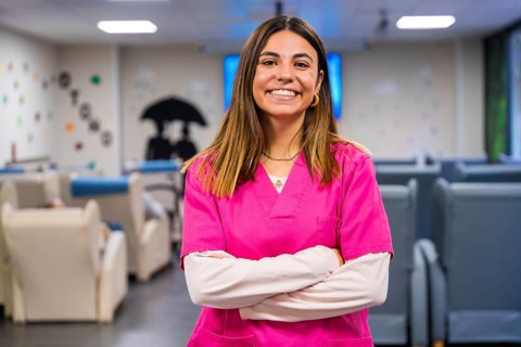 Portrait of a happy nurse standing with arms crossed in a geriatric
